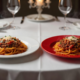 Fine dining masasında beyaz ve kırmızı tabakta spagetti bolognese, mum ve şarap kadehleri, çoklu duyusal yemek deneyimi