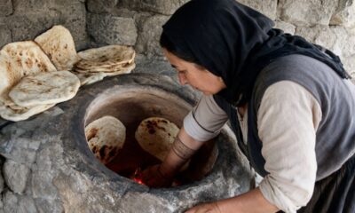 Geleneksel toprak tandır fırınında dikey ekmek pişiren kadın