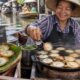 Tayland yüzen pazarında döküm tavada pişen Kanom Krok hindistan cevizi tatlısı